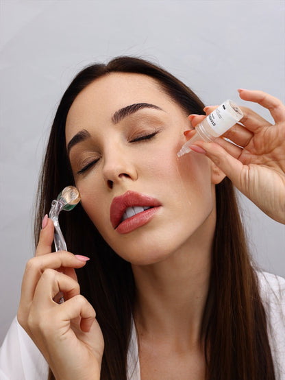 Woman using ROLLER Titanium Dermaroller (0.5 mm) while applying skincare serum for glowing skin.